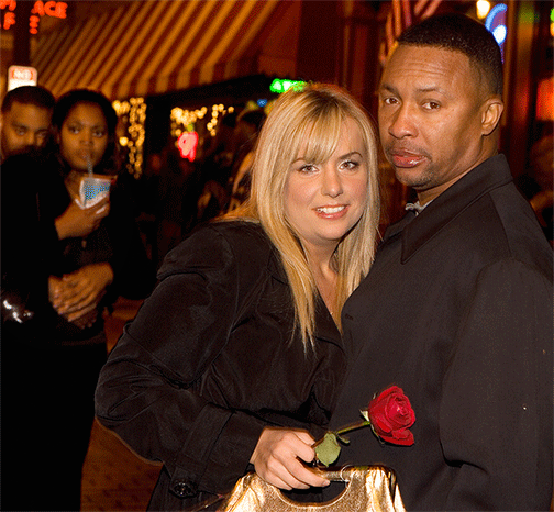 Picture of couple on Beale Street. She is holding red rose.
